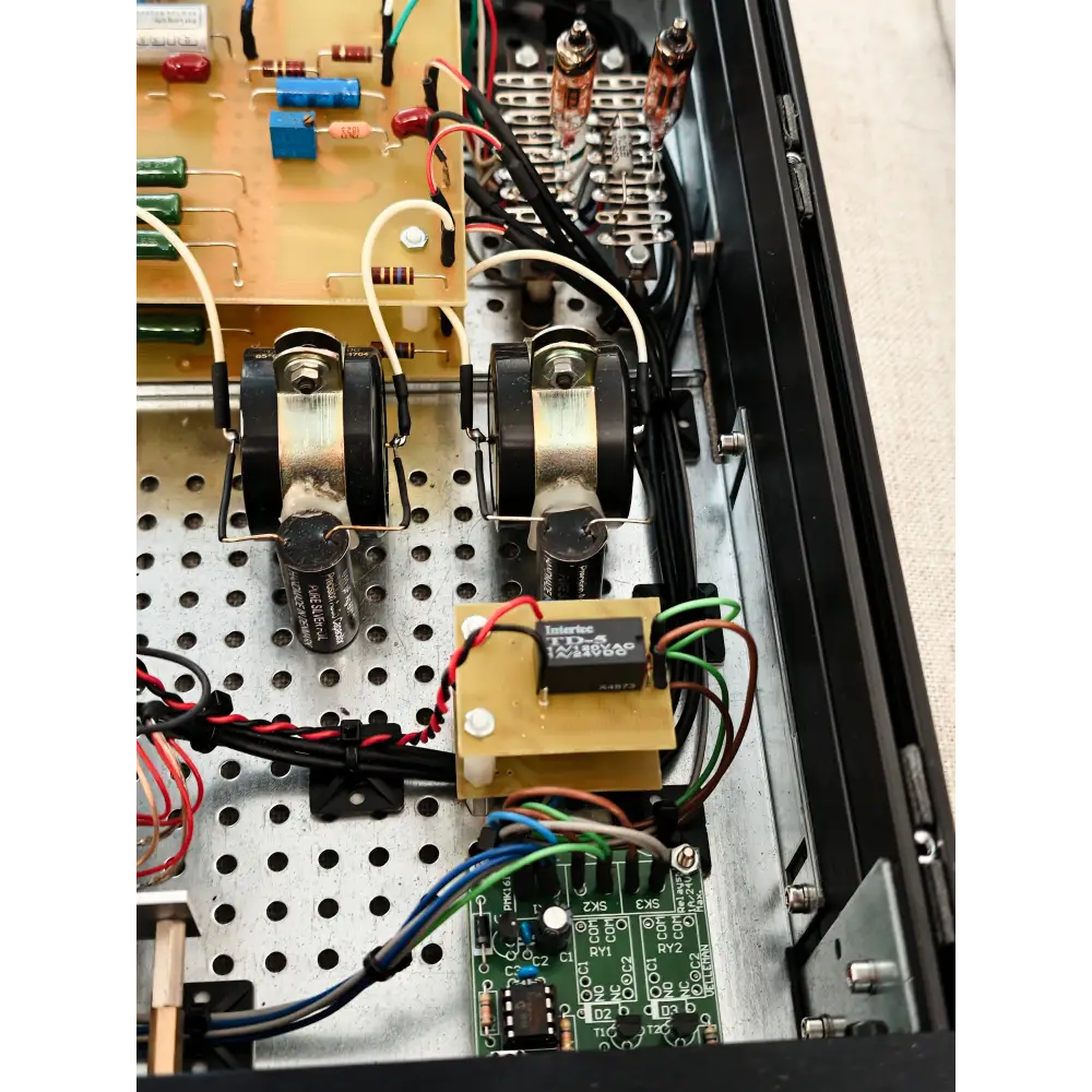 Schwarze zylindrische transformatoren mit metallischen oberseiten und gummibasen montiert auf perforiertem chassis für ayon audio conquistador highend schaltung