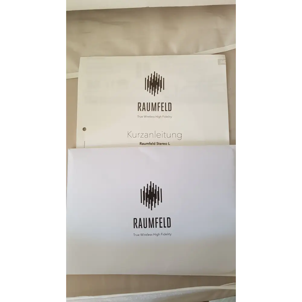 Zwei weiße Bedienungsanleitungen für Raumfeld Audio Produkte mit aufwendiger Tönebestückung