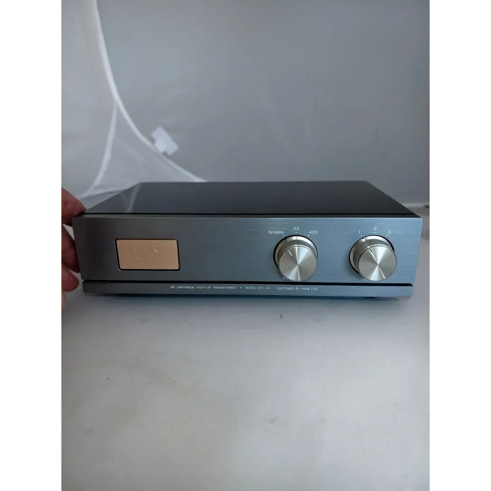 Silberne air tight ath-2a hifi-audioausrüstung mit matter schwarzer oberseite, zwei gebürsteten knöpfen und gravierter kupfertafel