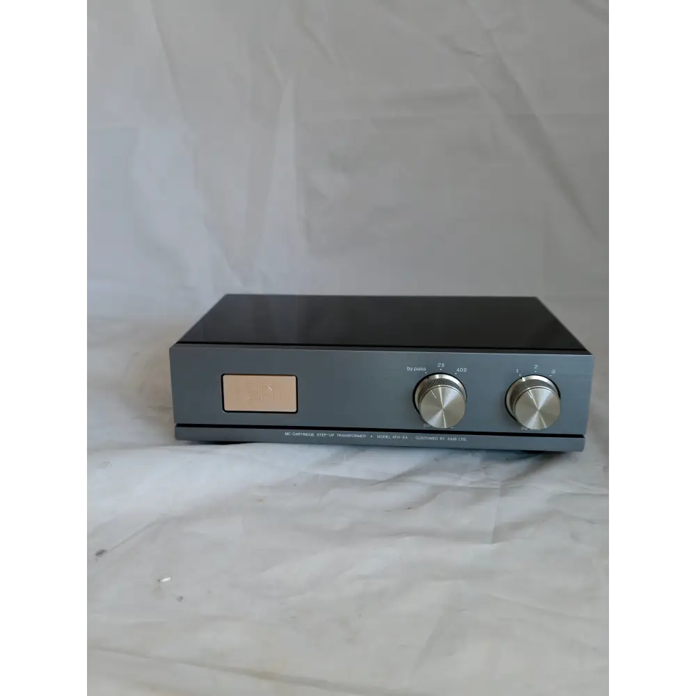 Graues rechteckiges hifi-audiogerät air tight ath-2a mit zwei silbernen knöpfen und beiger anzeigeplatte