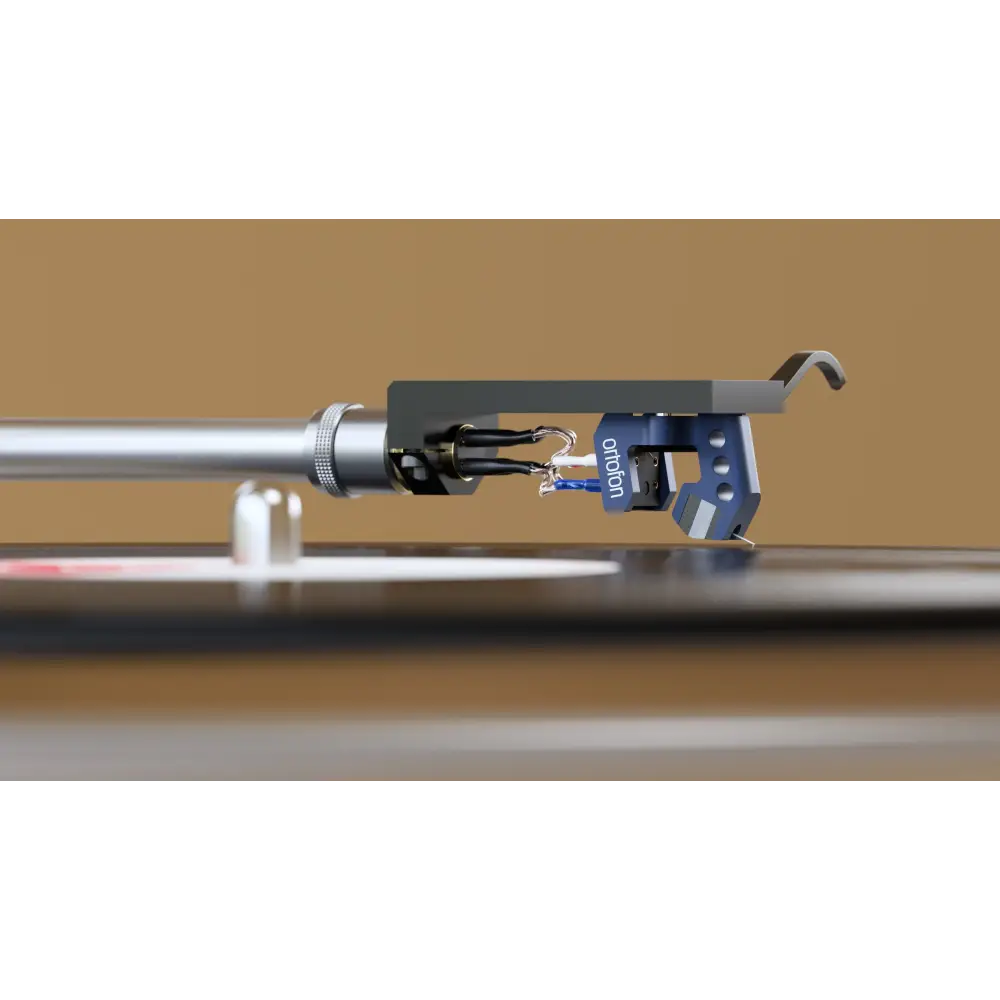 Blauer ortofon mc 90x stylus mit field stabilizing element und vergoldetes reinkupfer auf silbernem tonarm über vinylplatte